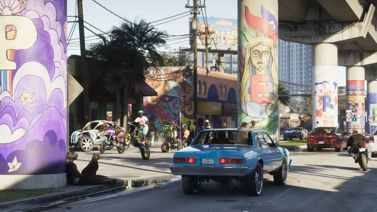 A classic blue muscle car on a mural-covered Vice City street in GTA 6, with bikes and pedestrians around
